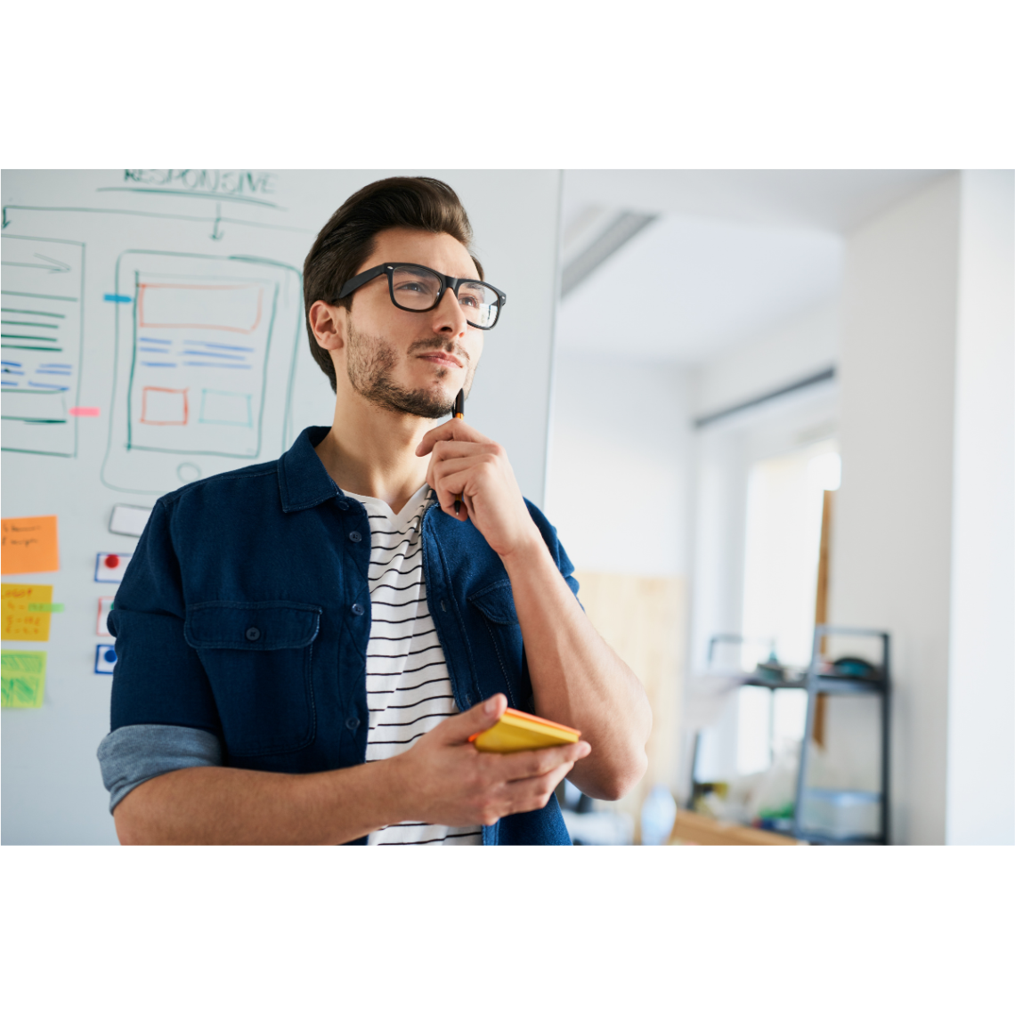 A man thinking with a notepad in his hand