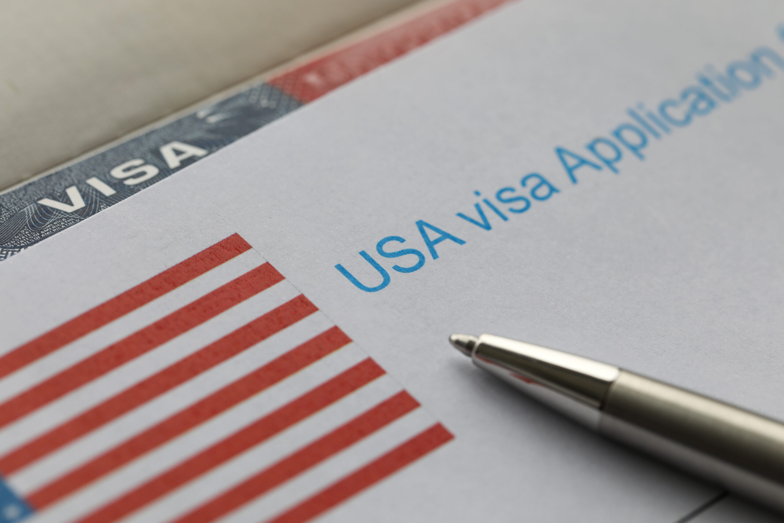 USA visa application paper form lying at passport page close-up